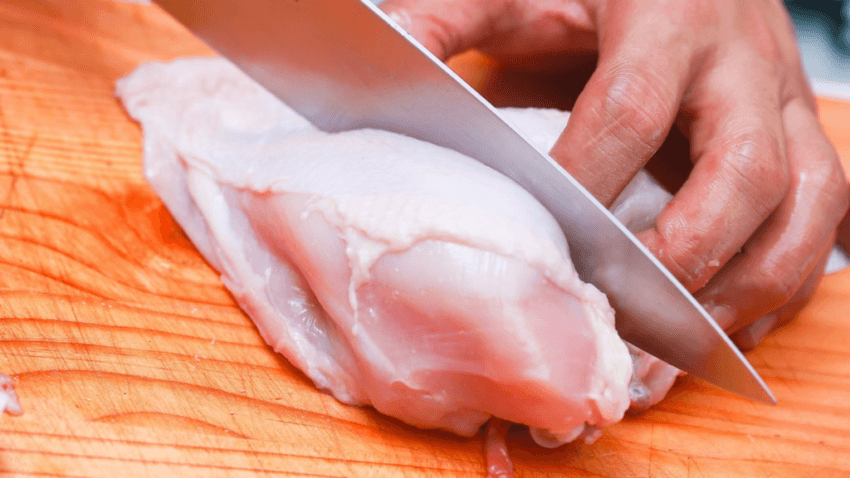 Man slicing chicken